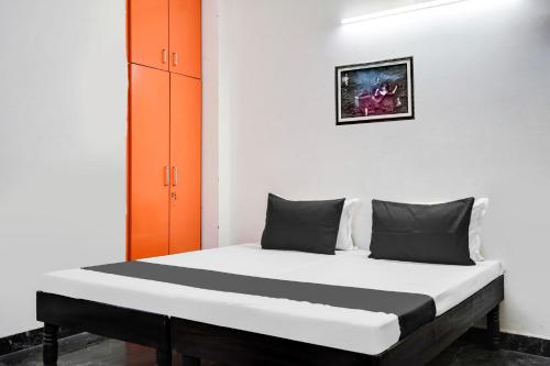 a bed in a room with an orange cabinet at Hotel O Royal residency in Dera Māndi