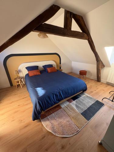 a bedroom with a large bed with a blue blanket at Cozy House in Yvetot