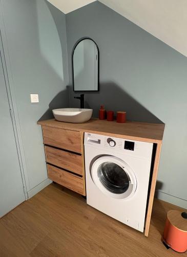 a bathroom with a washing machine and a mirror at Cozy House in Yvetot