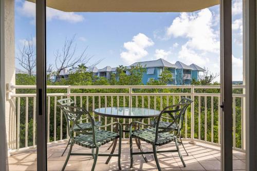 a patio with a table and chairs on a balcony at Tortuga Suite at Sunrise Suites Resort - Heated Pool, Hot Tub & Free Parking in Key West