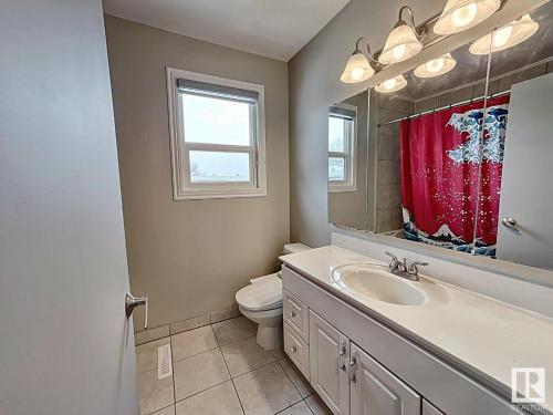 ein Badezimmer mit Toilette, Waschbecken und Spiegel in der Unterkunft UofA Bike Lane-Train-Bus- Southgate Mall, Cental in Edmonton