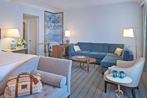 a living room with a blue couch and a bed at Peabody Memphis in Memphis