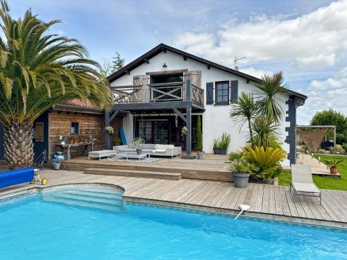 a house with a swimming pool in front of a house at La Belle Landaise 1809 Gîte Arridoulet 1 in Peyrehorade
