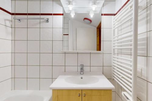 une salle de bain avec un lavabo et un miroir dans l'établissement Les Arolles - La Plagne 1800, à La Plagne Tarentaise