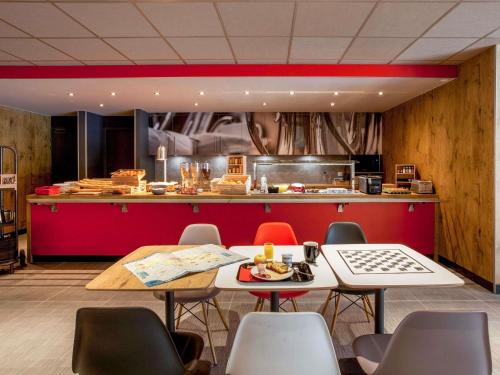 a restaurant with a table and chairs and a counter at ibis Cahors in Cahors