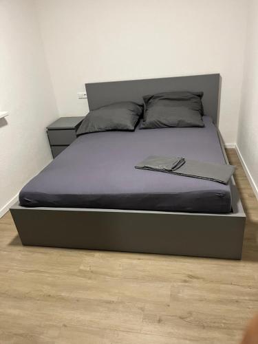 ein Bett in einem Schlafzimmer mit einem Bettgestell und einem Buch darauf in der Unterkunft Appartement 1 in Stuttgart