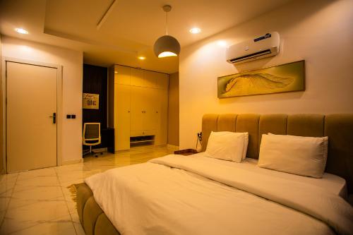 Un dormitorio con una cama grande con sábanas blancas. en Luxuryliveinn, en Mama