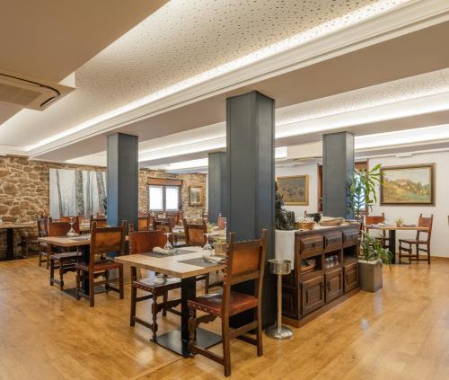 a restaurant with tables and chairs in a room at Hotel Rural Izar Ondo in Arbizu