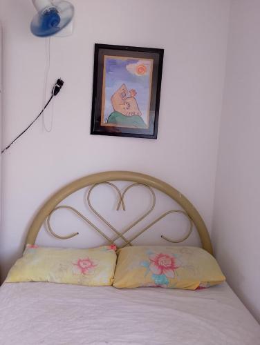a bed with a wooden head board with two pillows at Lar caprichoso in Aracaju