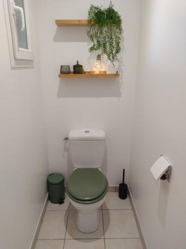 a bathroom with a toilet with a green seat at Médis Royan Saujon in Médis