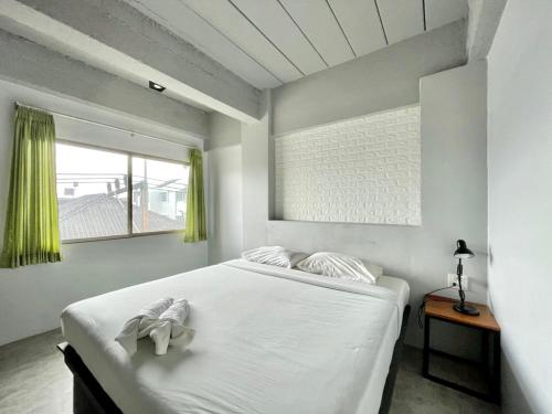 a bedroom with a large white bed with a window at THT by Thai Hotel Krabi in Krabi
