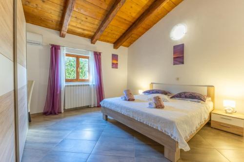 a bedroom with a large bed and a window at Villa Mainenti in Višnjan