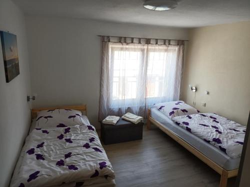 two beds in a room with a window at NEU! Ferienwohnung Storchennest OG in Pömmelte