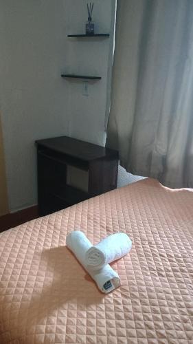 a white towel sitting on top of a bed at Quarto com Ar à 500m da praia Espaco Aconchego do Gugu in Arraial do Cabo