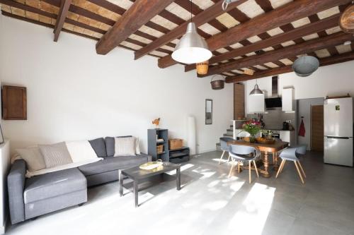 a living room with a couch and a table at Bardelours 2 Charming apartment with terrace in the heart of the villag in Saint-Bauzille-de-Montmel