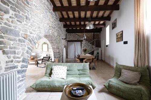 een woonkamer met een bank en een stenen muur bij Bardelours 4 - Charming villa with private pool - 6 bedrooms in Saint-Bauzille-de-Montmel