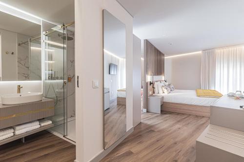 een badkamer met een bed, een wastafel en een spiegel bij Galega Villas in Milharado