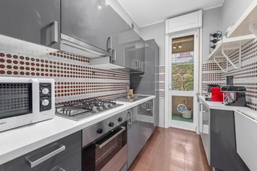 eine Küche mit Herd oberer Ofen neben einem Fenster in der Unterkunft Lakeside Hideaway - Lakefront & Central in Lecco