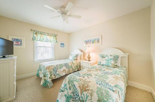 Un dormitorio con dos camas y un ventilador de techo. en K0510 Sunday Drive - Oceanfront, Pool, Hot Tub, Fall Availability!, en Whalebone