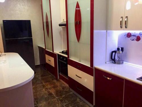 a kitchen with red and white cabinets and a counter at Elegant 3 bedroom apartment in center, next to Reppublic Square in Yerevan