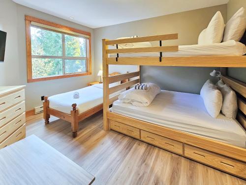 a bedroom with two bunk beds and a window at Timberline Lodges by Fernie Lodging Co in Fernie