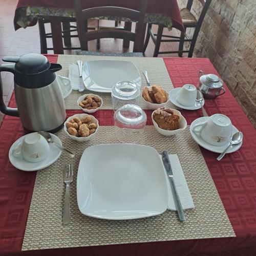 Villa Gatto Alice في روميتا ماريا: طاولة عليها أطباق وأواني بيضاء وطعام