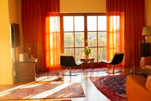 ウィーンにあるHerrlicher Ausblick über Wienの椅子と大きな窓のあるリビングルーム
