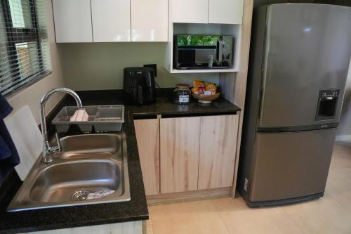 een keuken met een spoelbak en een roestvrijstalen koelkast bij Two on Bramble in Hilton