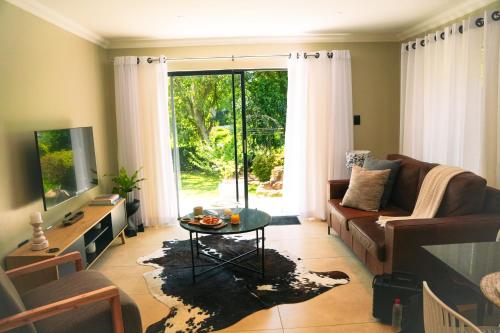 een woonkamer met een bank en een tafel bij Two on Bramble in Hilton