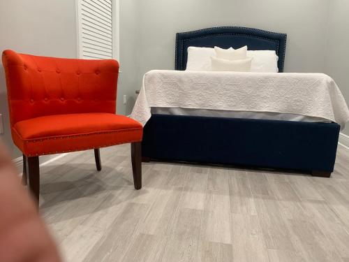 een slaapkamer met een bed en een stoel bij Creole Nest in New Orleans