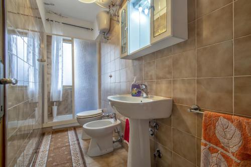 a bathroom with a sink and a toilet at Veranda Vista Mare Isola Rossa in Isola Rossa