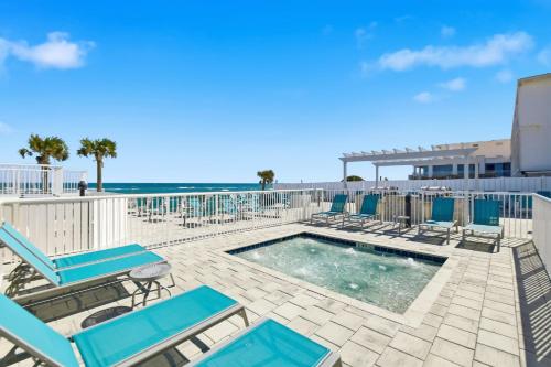 un patio con sedie, una piscina e l'oceano di The Maverick Resort - Ormond Beach a Ormond Beach