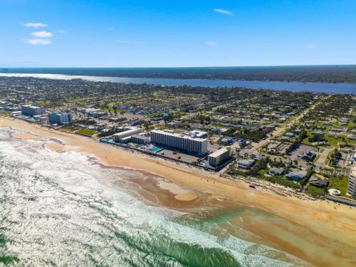 an aerial view of a beach with buildings and the ocean at The Maverick Resort - Ormond Beach in Ormond Beach