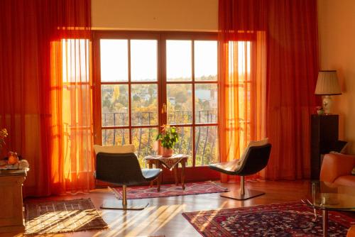 ウィーンにあるHerrlicher Ausblick über Wienの椅子と大きな窓のあるリビングルーム
