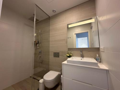 een badkamer met een wastafel, een toilet en een spiegel bij Luxury 2 bed apartment in Las Colinas in Orihuela-Costa