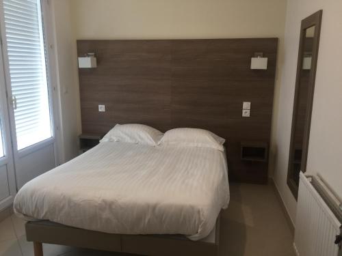 a bedroom with a large bed with a wooden headboard at Gite Le Logis Dauphinois in Roussillon en Isere