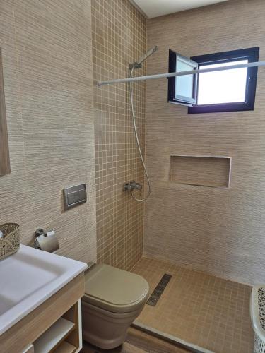 a bathroom with a toilet and a sink and a window at Villa Tezdaine in Midoun