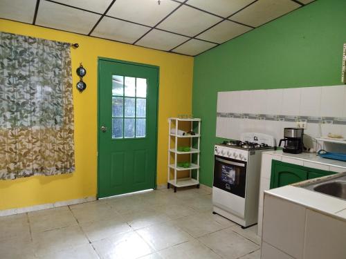 eine Küche mit grünen und gelben Wänden und einer grünen Tür in der Unterkunft Casa Vistagolfo in La Unión