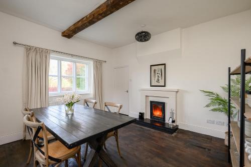 a dining room with a table and a fireplace at Historic Riverside House - Village, River Walks & Easy York Access in Cawood