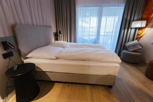 a bedroom with a large bed with a large window at VacationClub - Baltic Waves Resort Apartament A109 in Międzyzdroje
