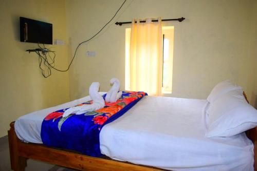 two white birds sitting on top of a bed at Divine home stays in Madikeri