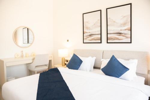 a bedroom with a large bed with blue pillows at Premium Studio in Yas Golf Collection in Abu Dhabi