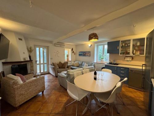 una cucina e un soggiorno con un tavolo e un divano di Cottage Wisteria a Prasco