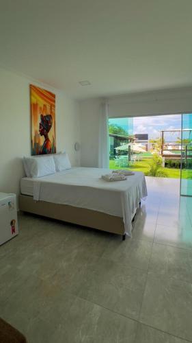 a bedroom with a large bed and a large window at Mambo beach gamboa in Cayru