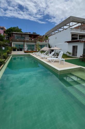 a swimming pool with chairs and a house at Mambo beach gamboa in Cayru
