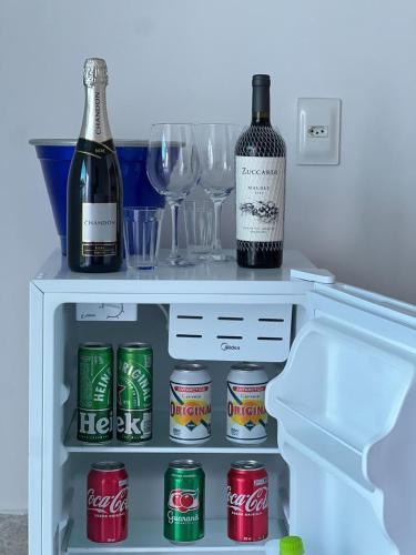 a refrigerator with two bottles of wine and glasses at Mambo beach gamboa in Cairu