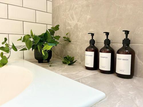 three bottles of wine sitting on a bathroom counter at Luxury 5 Bedroom House near York - Escrick in Escrick