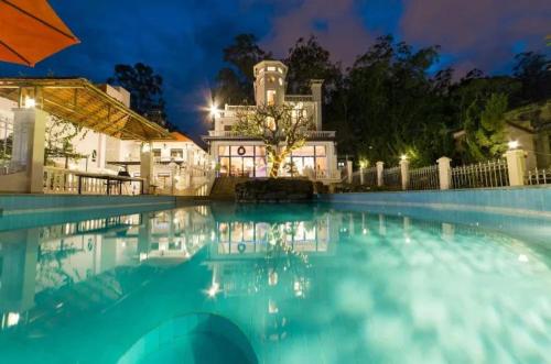 a swimming pool in front of a house at night at Dalat Villaa in Da Lat