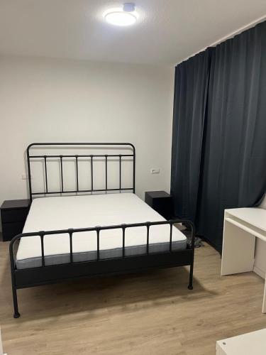 ein schwarzes Bett in einem Zimmer mit schwarzen Vorhängen in der Unterkunft Apartment in einem ehemaligen Hotel in Stuttgart