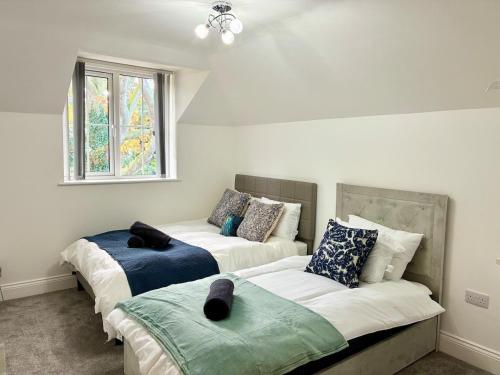 a bedroom with two beds and a window at Luxury 5 Bedroom House near York - Escrick in Escrick
